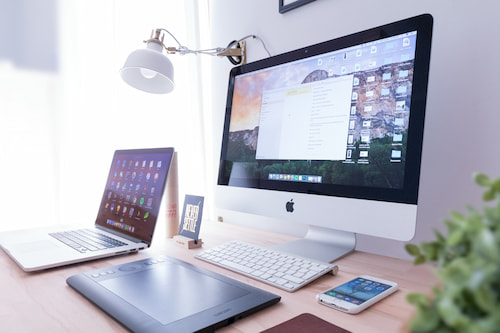 Phone and laptop sitting on a desk.